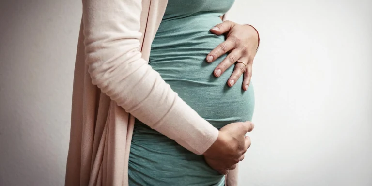 Bauch einer schwangeren Frau von der Seite fotografiert